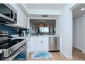 Modern kitchen with stainless steel appliances and blue tile backsplash at 6361 Bahia Del Mar Blvd # 605, St Petersburg, FL 33715