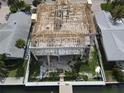 An aerial view of new home construction shows wood framing, block walls, and modern design near neighboring homes at 6457 1St Palm Pt, St Pete Beach, FL 33706