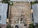 An aerial view shows new home construction with an exposed wood frame, capturing the essence of building and design at 6457 1St Palm Pt, St Pete Beach, FL 33706