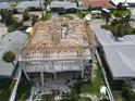 New home construction aerial showcases the modern building's framing near neighboring homes and sunny skies at 6457 1St Palm Pt, St Pete Beach, FL 33706