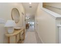 Bright and airy entryway with a console table and mirror, leading to the living area at 7013 Summer Holly Pl, Riverview, FL 33578