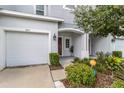 Townhome exterior showcasing attached garage, entryway, and landscaping at 7013 Summer Holly Pl, Riverview, FL 33578