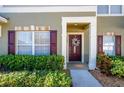 Townhome's front entrance with maroon door and holiday wreath at 12303 Foxmoor Peak Dr, Riverview, FL 33579