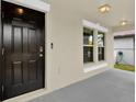 Dark brown front door and two windows on the porch at 16675 Carlton Pond St, Wimauma, FL 33598