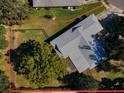 An aerial view showcases a fenced backyard, mature trees, and a partially covered patio at 2640 Westchester N Dr, Clearwater, FL 33761