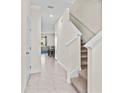 Bright and airy entryway with tile flooring, leading to the living area and staircase at 33055 Tulip Petal Ln, Wesley Chapel, FL 33545