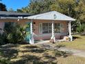 Pink house with white columns and landscaping, offering curb appeal at 6035 Grand Blvd, New Port Richey, FL 34652