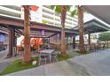 Outdoor seating area with tables, chairs, and palm trees at 1208 E Kennedy Blvd # 725, Tampa, FL 33602