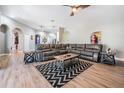 Cozy living room boasts a large sectional sofa, modern rug, and wood-look floors at 12306 Woodlands Cir, Dade City, FL 33525