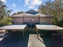 Two story home with covered parking and stairs leading to the entrance at 1901 Lennox E Rd # 1901, Palm Harbor, FL 34683