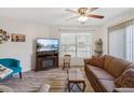 Living room with brown sofa, wood coffee table, and large TV at 1901 Lennox E Rd # 1901, Palm Harbor, FL 34683