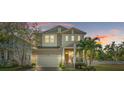 Two-story home with a charming front porch and well-manicured lawn at dusk at 518 Severn Ave, Tampa, FL 33606