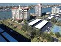 Aerial view showing condo building, parking, and tennis courts at 700 Island Way # 206, Clearwater Beach, FL 33767