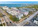 This is an aerial view of a waterfront apartment community with lush landscaping and plenty of parking at 147 Bluff View Dr # 204, Belleair Bluffs, FL 33770
