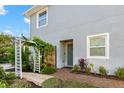 Side entrance with brick walkway and trellis at 281 Ashley Ct, Dunedin, FL 34698