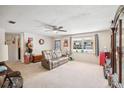 Bright living room featuring a comfortable reclining sofa and large window at 38919 3Rd Ave, Zephyrhills, FL 33542