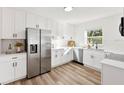 Bright kitchen with white cabinets, stainless steel appliances, and wood-look floors at 523 Deville E Dr, Largo, FL 33771