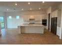 Spacious kitchen featuring a large island, stainless steel appliances, and light-colored cabinetry at 10157 Beachwalk Dr, Englewood, FL 34223