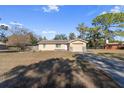 Tan house with stone accents, attached garage, and a large yard at 12347 Comstock St, Spring Hill, FL 34609