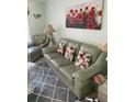 Living room with green leather sofa and glass coffee table at 4199 38Th S Ave # I, St Petersburg, FL 33711