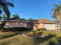 Single-story house with brown roof, attached garage, and manicured lawn at 5105 Garden Vale Ave, Tampa, FL 33624