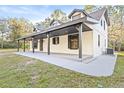 White farmhouse with a long covered porch and large windows at 8057 Shaw Rd, Brooksville, FL 34602