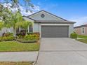 House exterior featuring a gray front door and landscaped yard at 9626 Channing Hill Dr, Ruskin, FL 33573