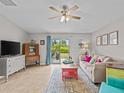 Living room with a comfy couch, a large TV, and access to a patio at 9626 Channing Hill Dr, Ruskin, FL 33573