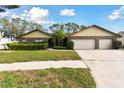 House exterior featuring a three-car garage and lush lawn at 1121 Belladonna Dr, Brandon, FL 33510