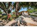 House exterior showcasing a long driveway and mature landscaping at 1201 Kapok Cir, Clearwater, FL 33759