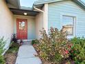 Inviting front entry with red door and landscaping at 1622 Palm Leaf Dr, Brandon, FL 33510