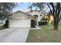 Charming two-story home featuring a well-manicured lawn, mature trees, and an attached two-car garage at 18127 Sandy Pointe Dr, Tampa, FL 33647