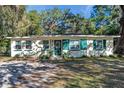 Ranch home with green shutters, nestled amongst lush trees at 29 Croom Rd, Brooksville, FL 34601