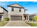 Two-story house with gray siding, brown garage door, and landscaping at 5508 Rainwood Meadows Dr, Apollo Beach, FL 33572