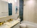 Spa-like bathroom with double vanity, teal tile, and a bathtub at 5516 Golden Dr, Tampa, FL 33634