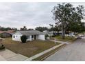 Single story house with red door and attached garage, street view at 5601 Lima Dr, Holiday, FL 34690