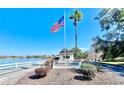 Heather Sound community entrance featuring well-manicured landscaping, an American flag, and a view of the lake at 9107 Lingrove Rd, Weeki Wachee, FL 34613