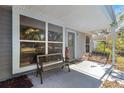 Covered front porch with bench seating, offering a relaxing outdoor space at 3821 Pebble Ct, Palm Harbor, FL 34684