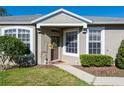 Front entry of charming house featuring a covered porch and lush landscaping at 5733 Heronpark Pl, Lithia, FL 33547