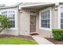 Inviting front entrance with a decorative wreath and brick walkway, flanked by lush landscaping at 5733 Heronpark Pl, Lithia, FL 33547