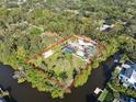 Aerial view showing home, pool, and expansive lot bordering a canal at 1690 Fox Rd, Clearwater, FL 33764