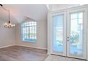 Bright dining room with wood-look floors, large window, and french doors at 18017 Kings Park Dr, Tampa, FL 33647