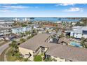 Aerial view showcasing condo building, pool, and nearby waterfront at 460 Paula S Dr # 101, Dunedin, FL 34698