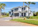 Two-story modern home with palm trees, a spacious driveway, and a well-manicured lawn at 5951 Bay Dr, Gulfport, FL 33707