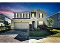 Two-story house with a brick driveway, lit at night at 1192 Multiflora Loop, Lutz, FL 33558