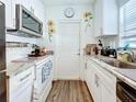 Small galley kitchen with white cabinets and granite countertops at 1514 Sadlon Ave, Clearwater, FL 33756