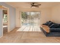 Living room with sliding glass doors leading to a pool view at 330 Promenade Dr # 207, Dunedin, FL 34698