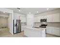Modern kitchen with stainless steel appliances, white cabinets, and a central island, perfect for cooking and entertaining at 3952 Big Sky Dr, Spring Hill, FL 34604