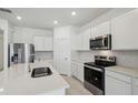 Bright kitchen with white cabinetry, stainless steel appliances, and center island at 3952 Big Sky Dr, Spring Hill, FL 34604