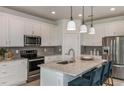 Modern kitchen with white cabinets, granite island, and stainless steel appliances at 3952 Big Sky Dr, Spring Hill, FL 34604